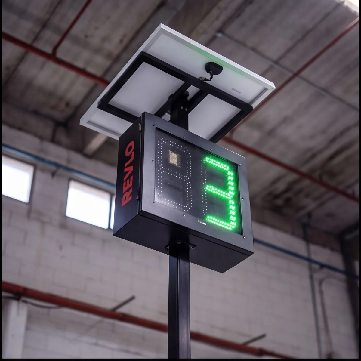 Display eletrônico de velocidade Revlo montado em poste, com placa solar acima